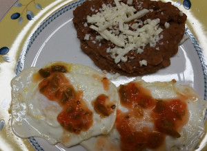 Una foto de Huevos estrellados con frijoles y salsa de molcajete