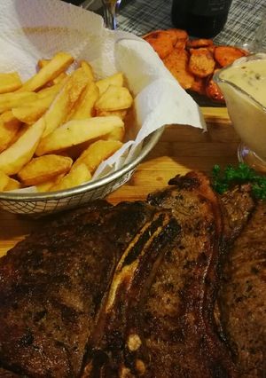 A picture of Mushroom sauce served with steak & chips.