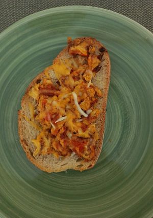 A picture of Scrambled Eggs Toast with Tomato and Cheddar.