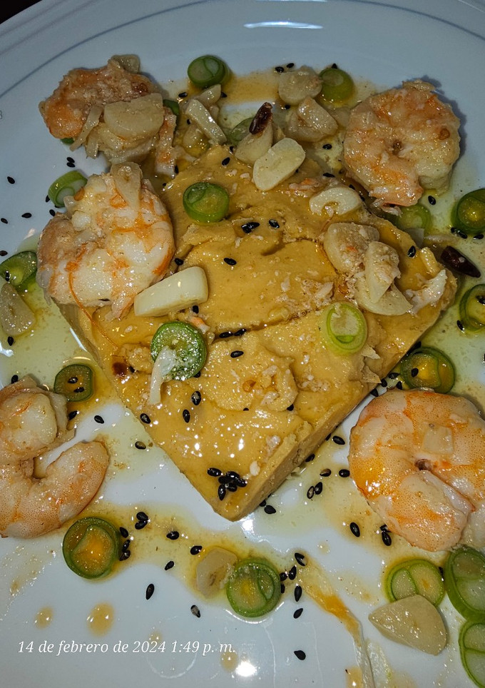 Una foto de Puré de garbanzos con langostinos al ajillo