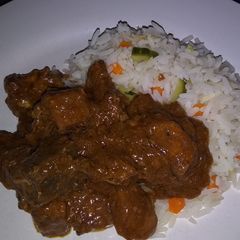A picture of Rice with cucumbers, carrots and beef stew.