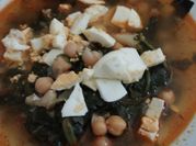 Una foto de garbanzos con espinacas comino