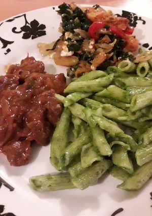 A picture of Penne pasta in basil pesto.