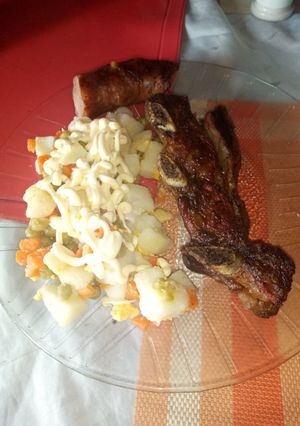 Una foto de Asado al carbón con ensalada rusa