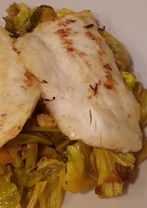 Una foto de Filetes de merluza con base de col