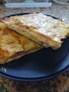 Una foto de Empanada de pollo con bechamel, bacon, queso y jamón cocido