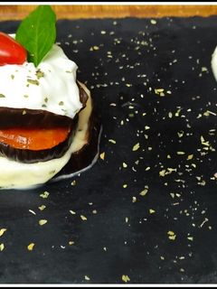 Una foto de Torre de berenjena templada con salsa tzatziki