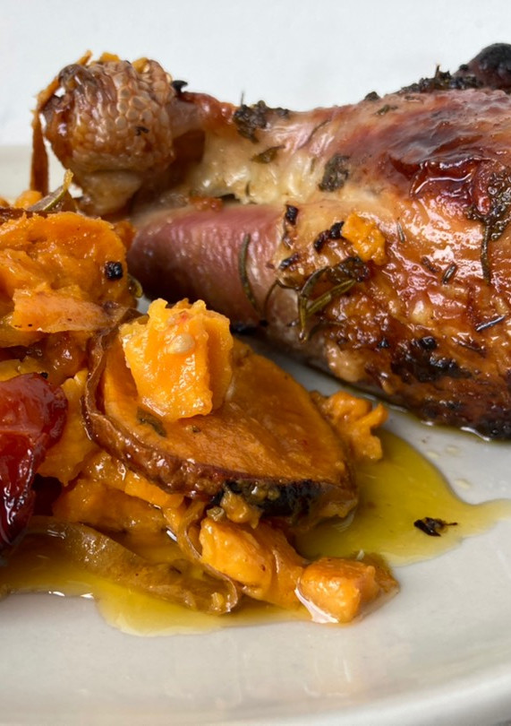 Una foto de Muslos de pavo al horno con batatas y tomates