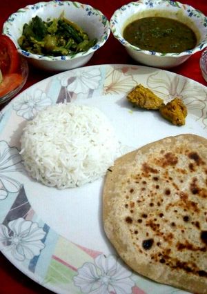A picture of Dal,rice,chapati,bhindi with salad and pickle.