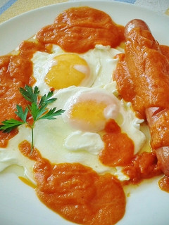 Una foto de Huevos fritos con frankfurt y sofrito de tomate