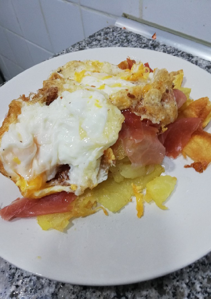 Una foto de Huevos rotos con jamón