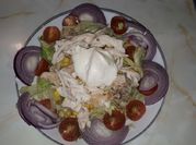 Una foto de ensalada de pollo con tomates cherry