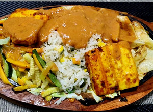 A picture of Grilled paneer sizzler with Makhni sauce.