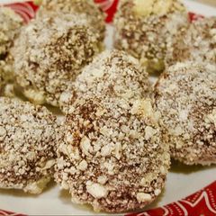 A picture of Almond chocolate truffle with white chocolate coating .