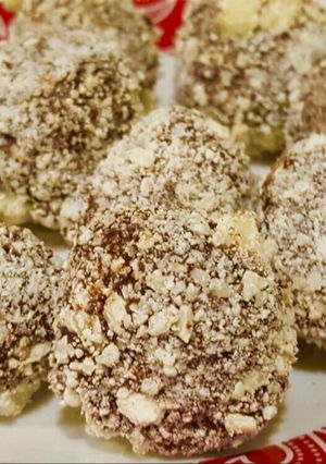 A picture of Almond chocolate truffle with white chocolate coating .