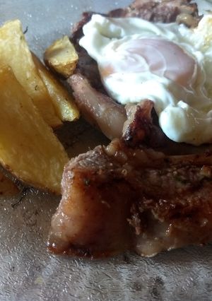 Una foto de Bife a caballo con papas rústicas