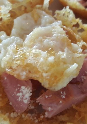 Una foto de Cesta de patatas fritas con huevo, queso y jamón