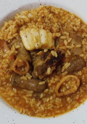 Una foto de Arroz mar y montaña de costillas, salchichas, bacalao y calamar