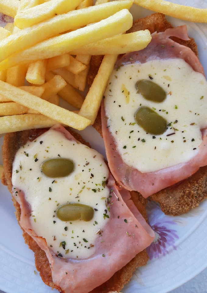 Una foto de Milanesas a la Napolitana con papas fritas