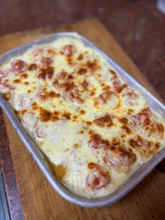 Una foto de Puré de papa gratinado con cherrys, cebolla y ajo