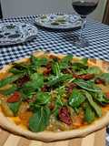 Pizza vegana de rúcula com tomate seco