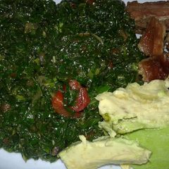 A picture of Sukuma wiki/kales and fried pork.