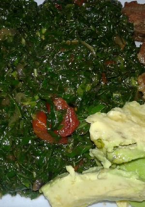 A picture of Sukuma wiki/kales and fried pork.