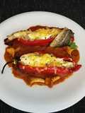Pimientos rellenos con bacalao y arroz sobre salsa de tomate