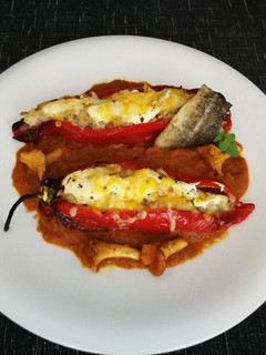 Una foto de Pimientos rellenos con bacalao y arroz sobre salsa de tomate