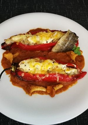 Una foto de Pimientos rellenos con bacalao y arroz sobre salsa de tomate