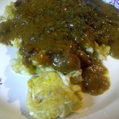 A picture of Bacon curry sauce on eggs.