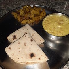 A picture of Boondi ki kadhi with aalu ki sabzi and roti.
