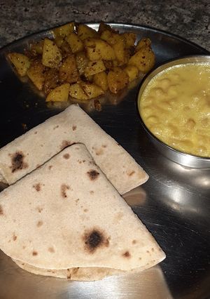 A picture of Boondi ki kadhi with aalu ki sabzi and roti.