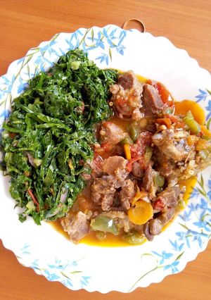 A picture of Stewed Goat meat with sauted kales.