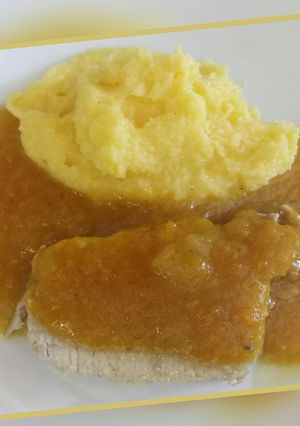 A picture of Roast pork with apple gravy served with polenta.