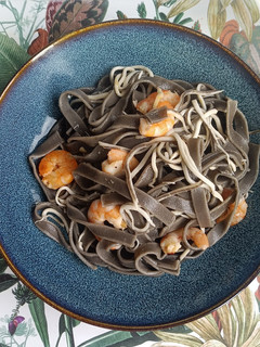 Una foto de Tagliatelle nero di sepia con gulas y langostinos