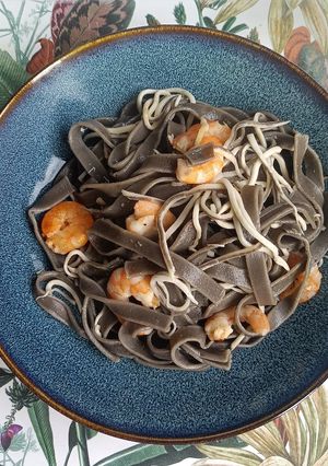 Una foto de Tagliatelle nero di sepia con gulas y langostinos