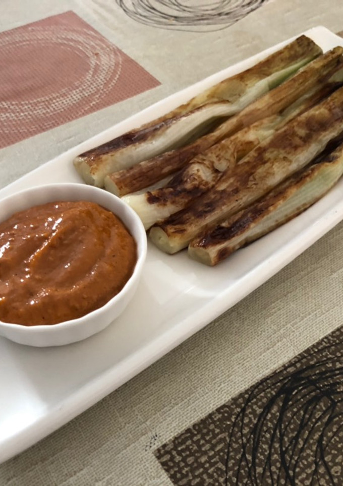 Una foto de Calçots o cebolla tierna en Lékué con salsa romesco