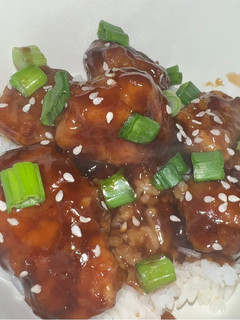 A picture of Orange Chicken with White Rice.
