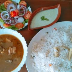 A picture of Veg pulao with chicken gravy.