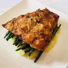 A picture of Pan fried fish over French beans and mashed potatoes.