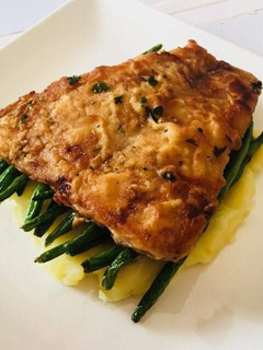 A picture of Pan fried fish over French beans and mashed potatoes.