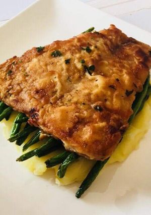 A picture of Pan fried fish over French beans and mashed potatoes.