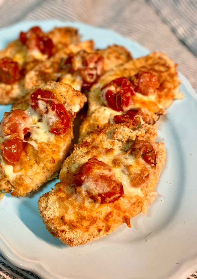 Una foto de Pechugas empanadas en airfryer con tomates asados y mozzarella