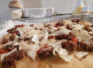 Foto di Pizza con salsiccia funghi porcini e Carpaccio di parmigiano