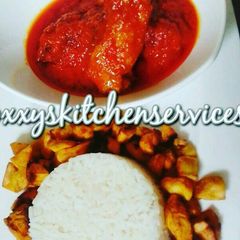 A picture of Palm oil chicken stew served with white rice and fried plantain.
