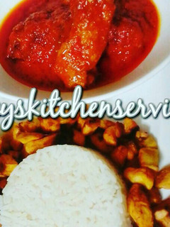 A picture of Palm oil chicken stew served with white rice and fried plantain.