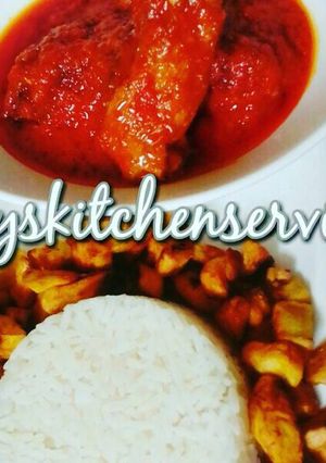 A picture of Palm oil chicken stew served with white rice and fried plantain.