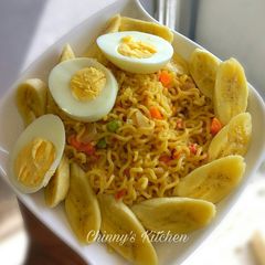 A picture of Stir fry noodles paired with egg and banana.