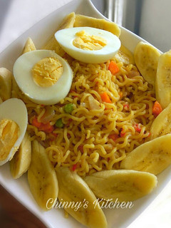 A picture of Stir fry noodles paired with egg and banana.